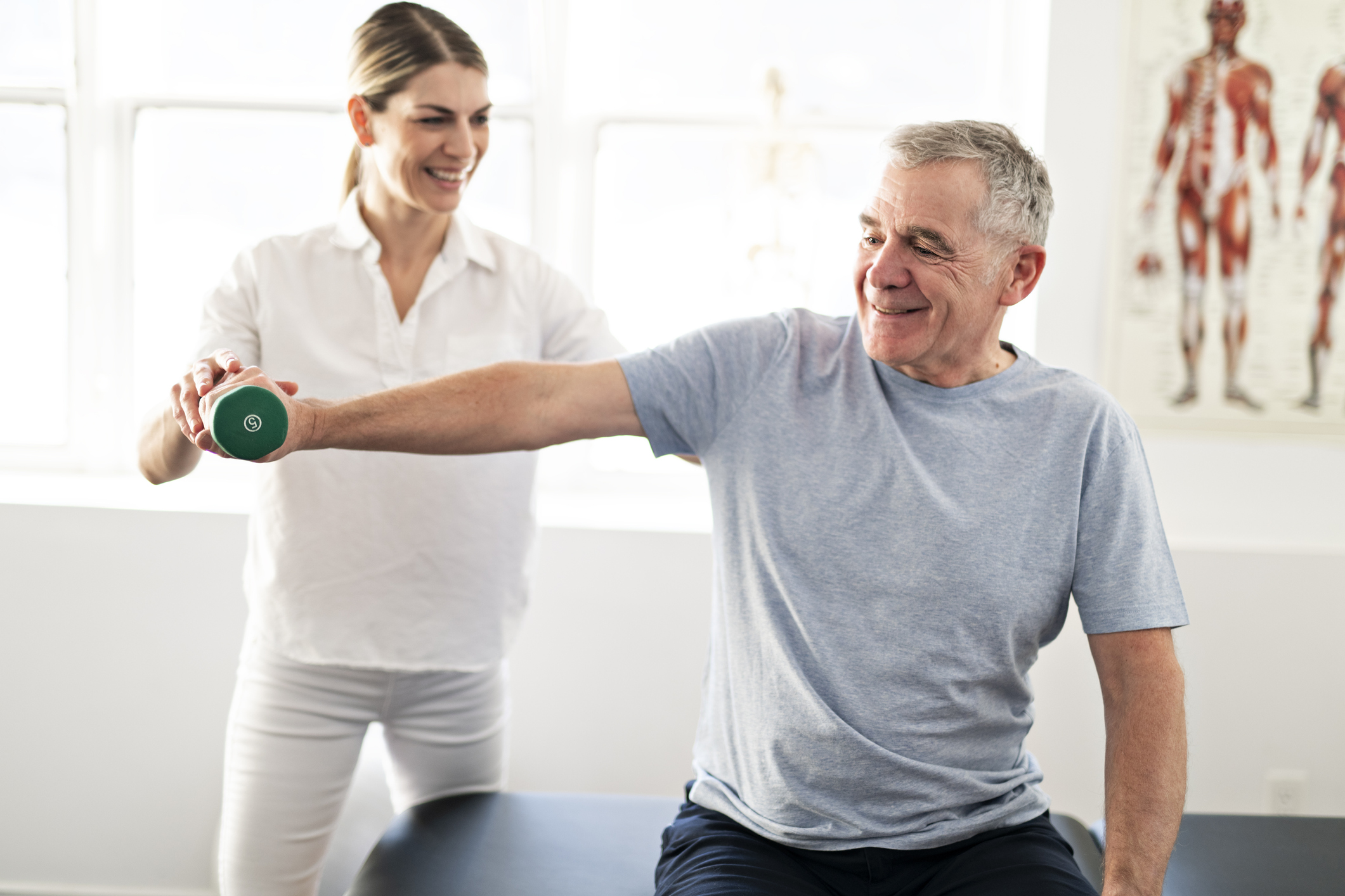 Modern rehabilitation physiotherapy worker with senior client