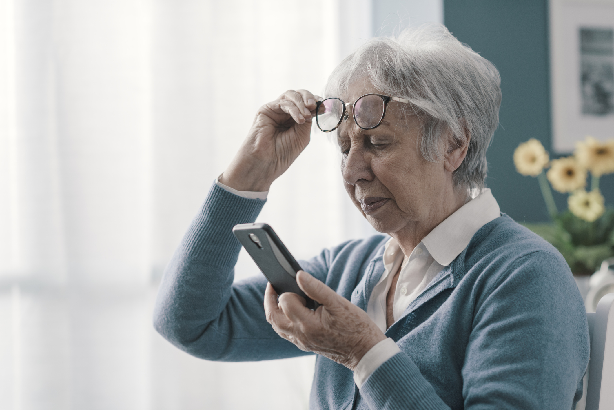 Senior woman having a hard time reading a text message on her phone