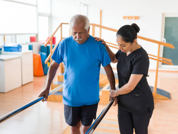 a female nurse helping an old man with physical therapy