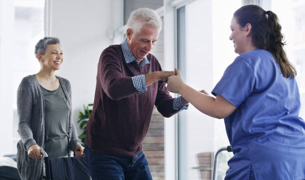 a senior man being helped by a nurse to stand