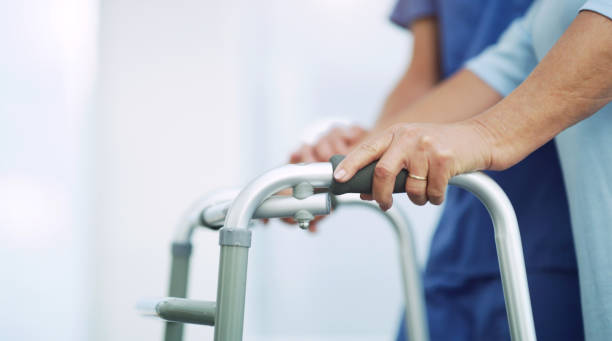 An elderly woman being assisted by a nurse