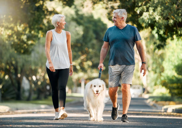 An elderly couple walking their dog